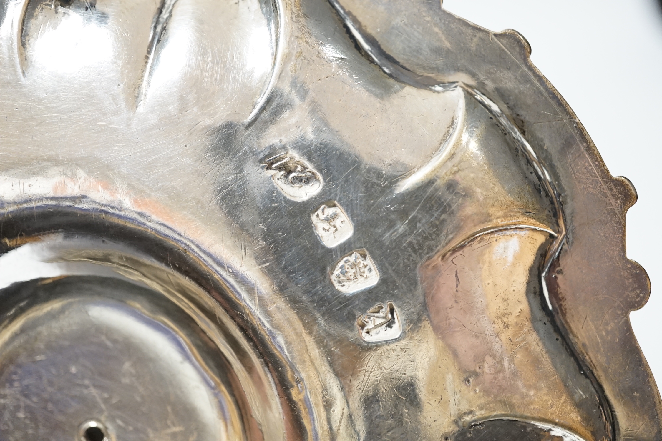 A George II silver chamberstick, with shell border, on three scroll feet, William Grundy, London, 1756, with extinguisher(marks rubbed), overall 18.5cm, 14.1oz.